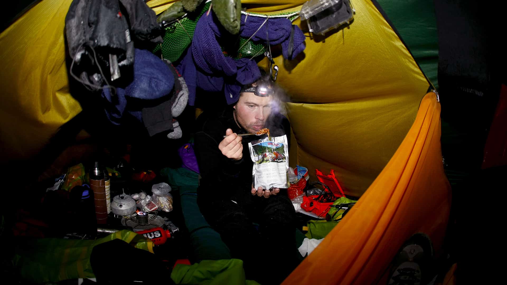 Danmark rundt i kajak, isvinteren 2009-10, foredrag, Erik B. Jørgensen, spiser frysetørretmad i sit telt, foto Rene Schütze