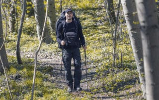 Billede af Erik B. Jørgensen, der vandre i skoven med rygsæk, fototaske og vandrestave. Foto Claus Lillevang