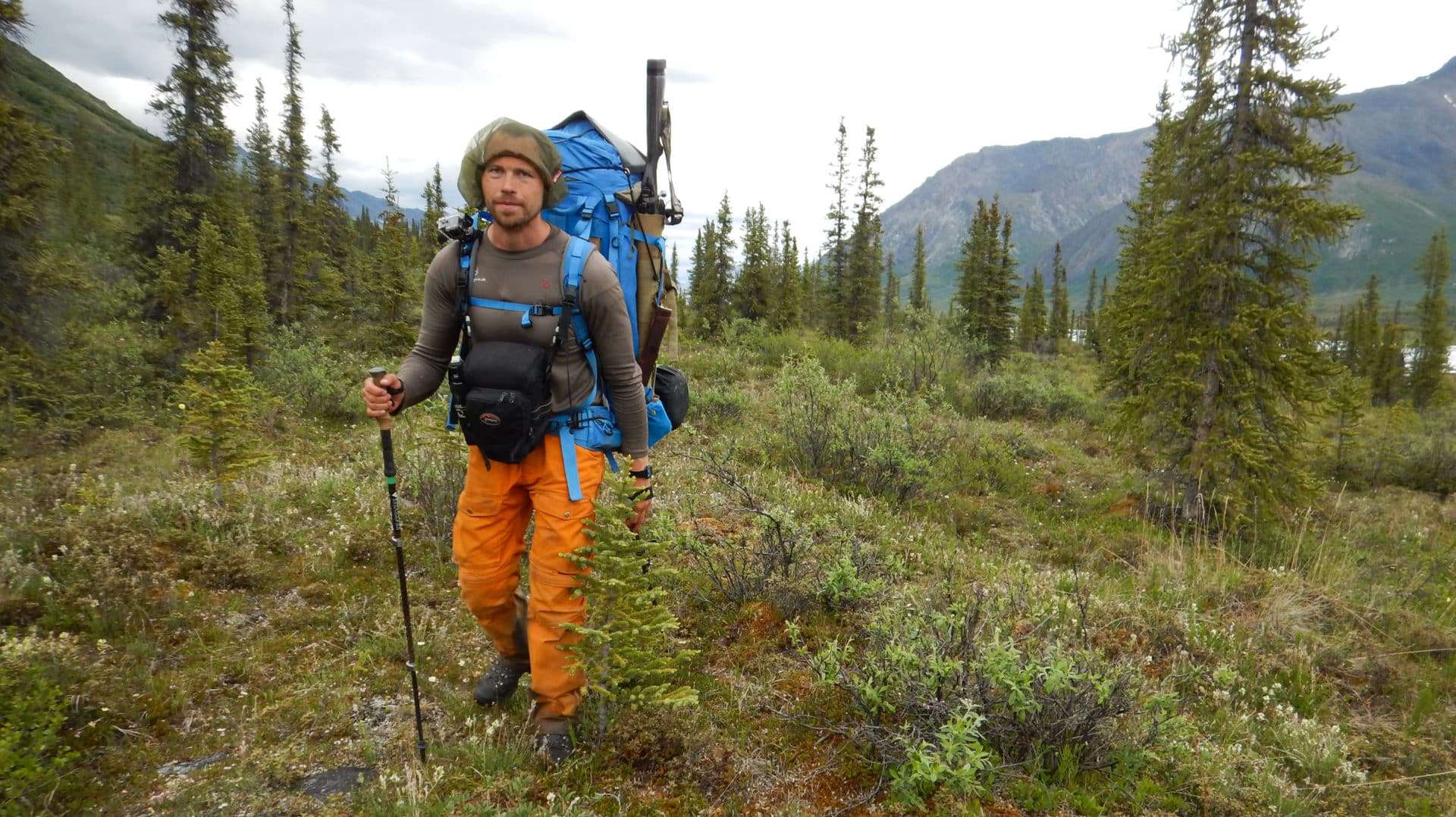 Billede af Erik B. Jørgensen der vandre med stor rygsæk og gevær under "Alaska på tværs"
